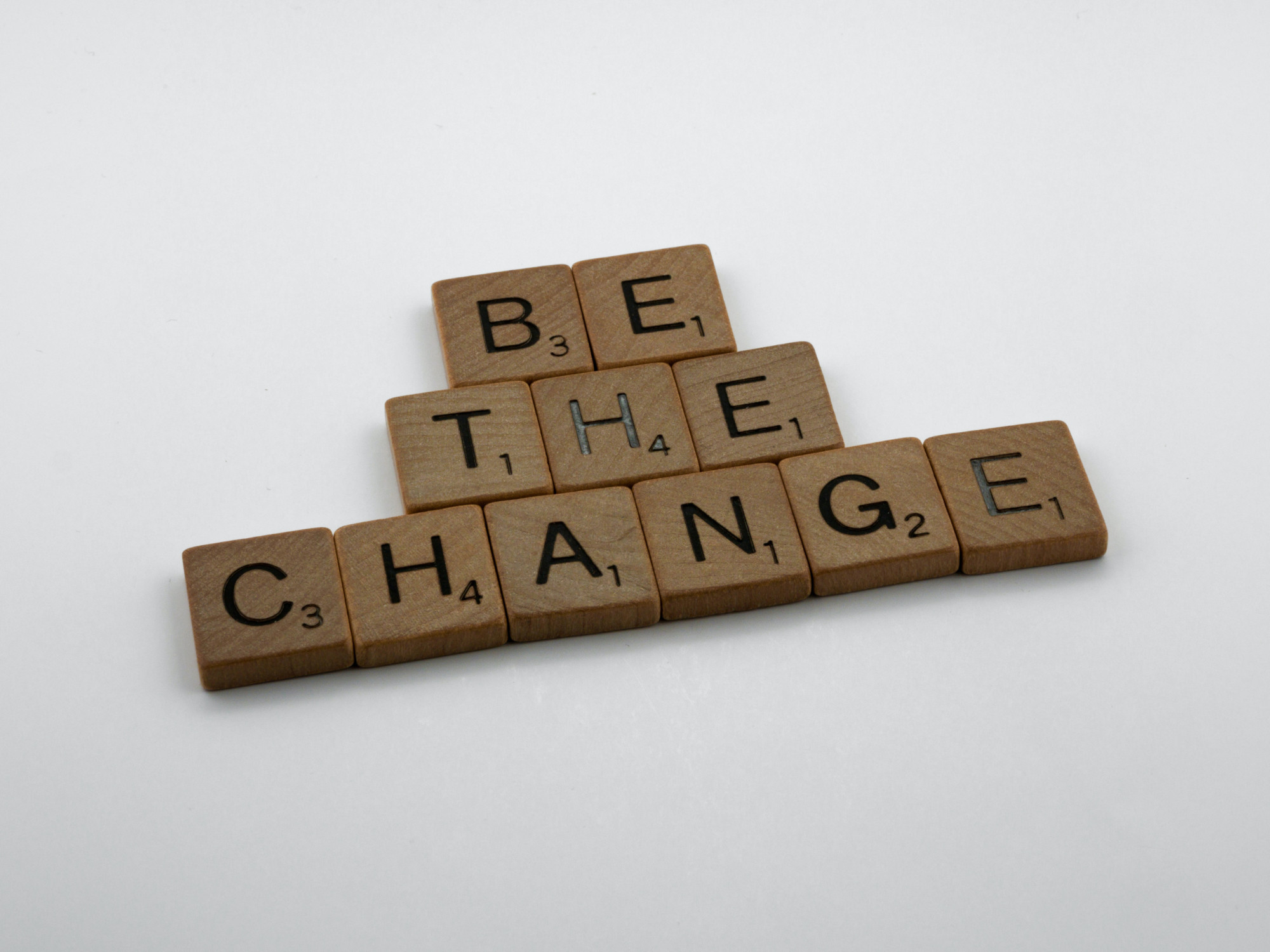 The words be the change spelled out in scrabble letters on a white background